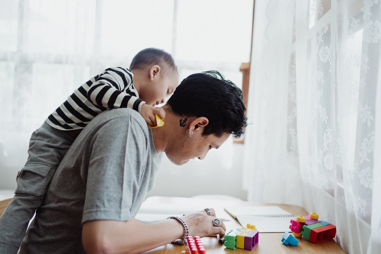 Father and son play with colorful blocks indoors, capturing a joyful bonding moment.